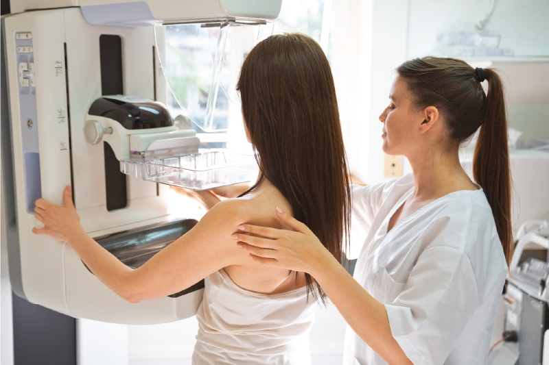 nurse with woman getting screening mammogram